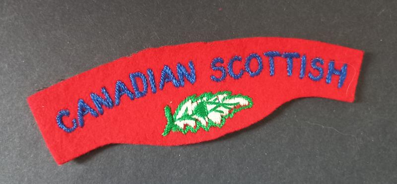 A attractive - typical British made - un-issued Canadian Scottish embroided shoulder title