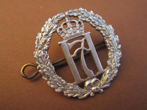 A neat example of a scarce Norwegian Free Forces British made Haakon 7 silver hallmarked capbadge