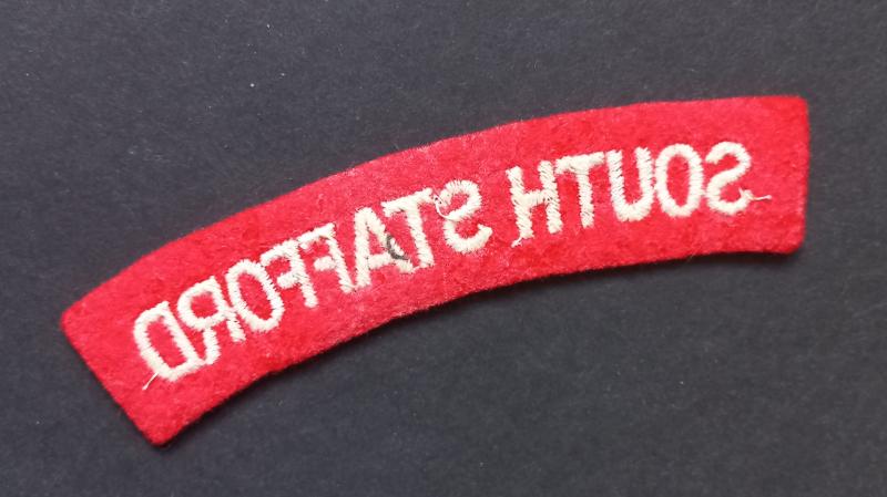 A neat un-issued (white on red) embroided South Stafford shoulder title