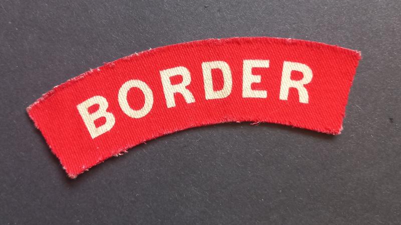 A attractive - albeit regrettably single - printed unissued Border Regiment shoulder title