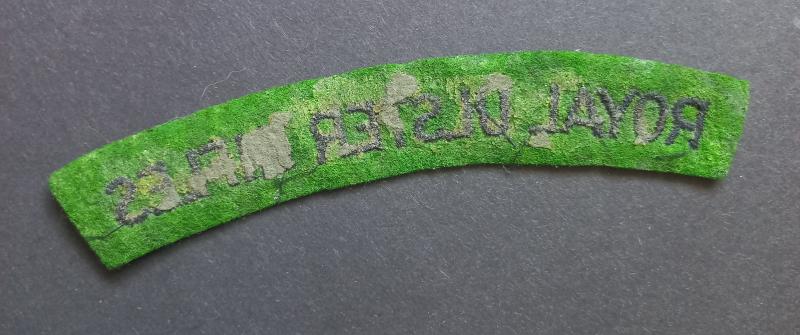 A attractive - un-issued - Royal Ulster Rifles black on green embroided shoulder title