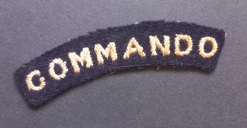 A superb - albeit regrettably single - early white on black embroided commando shoulder title